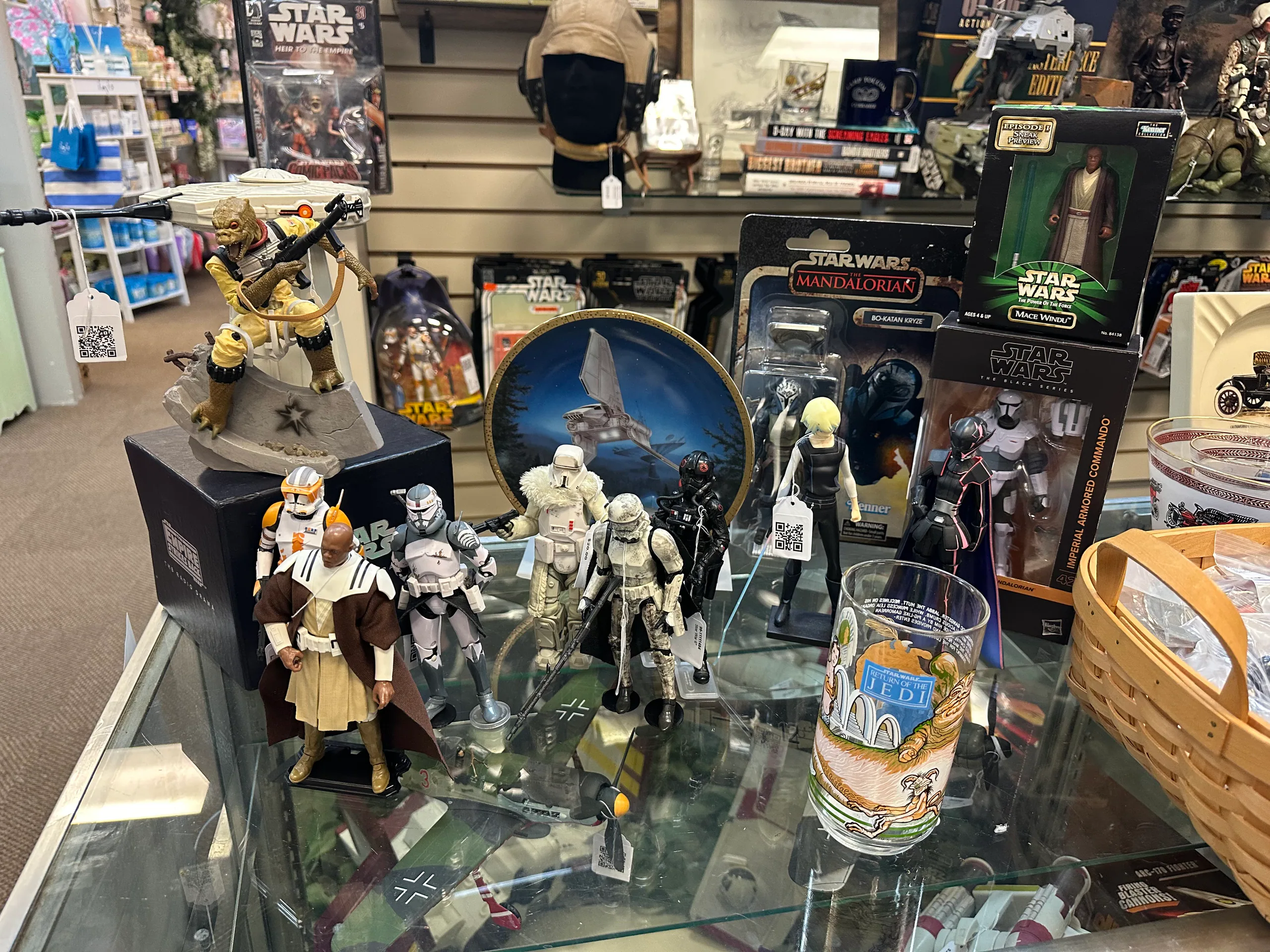 Loose and carded Star Wars figures arranged across a glass display